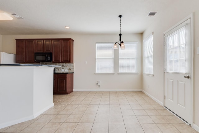 kitchen with backsplash, an inviting chandelier, decorative light fixtures, white fridge, and dark brown cabinetry