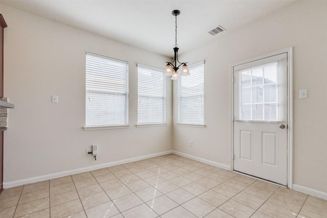 unfurnished dining area featuring an inviting chandelier and light tile patterned flooring