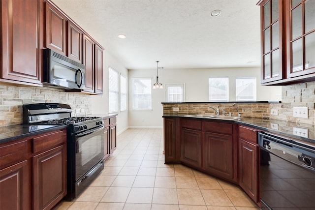 kitchen with black appliances, plenty of natural light, pendant lighting, and sink