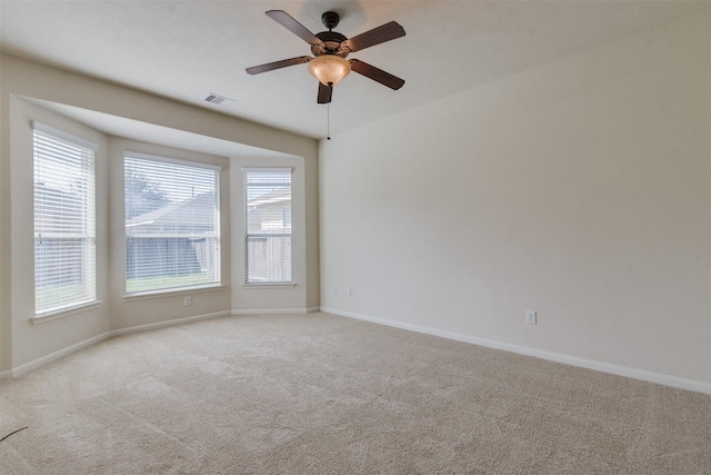 carpeted spare room featuring ceiling fan