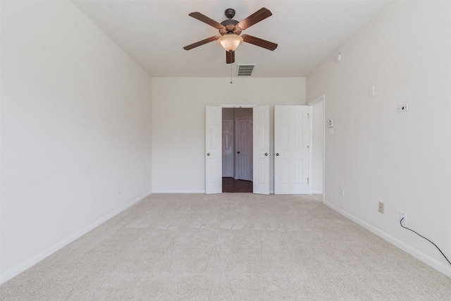 empty room with ceiling fan and light carpet