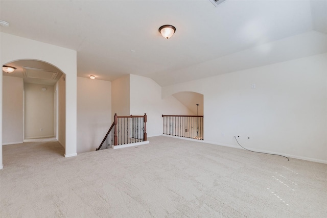 spare room with light colored carpet and lofted ceiling