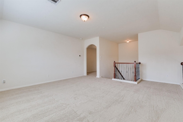 empty room featuring light colored carpet and vaulted ceiling