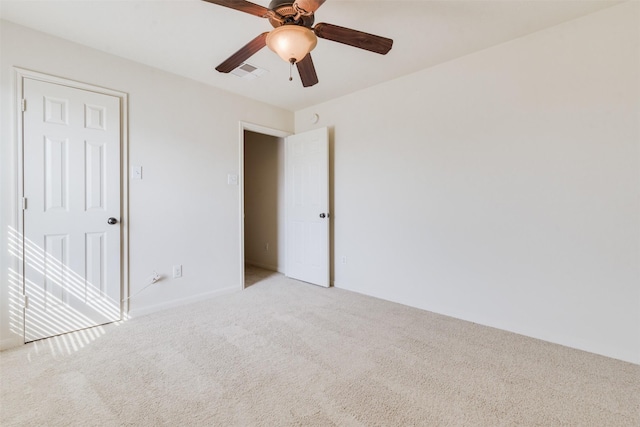 empty room featuring ceiling fan and light colored carpet