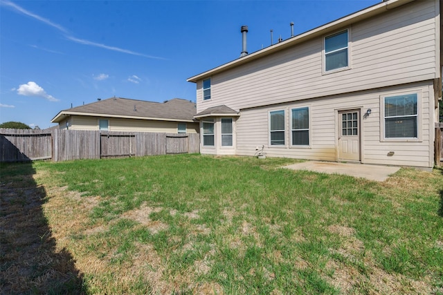 rear view of house with a yard and a patio