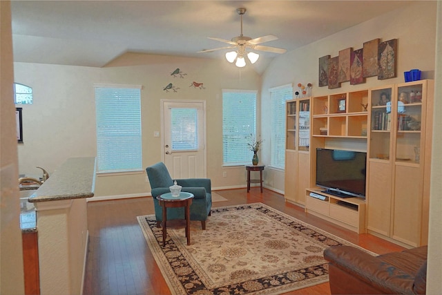 living room featuring ceiling fan, wood-type flooring, and vaulted ceiling