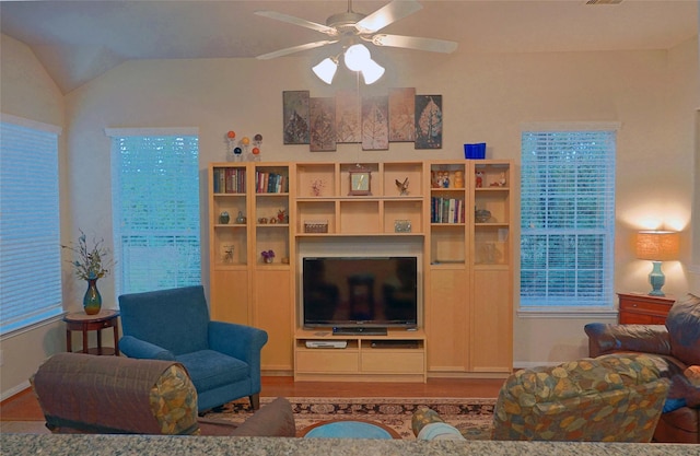 living room with hardwood / wood-style floors, ceiling fan, and vaulted ceiling