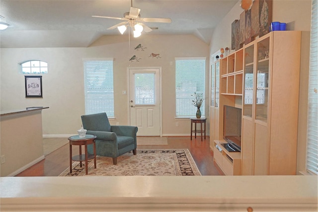 living area with ceiling fan, light hardwood / wood-style floors, and vaulted ceiling