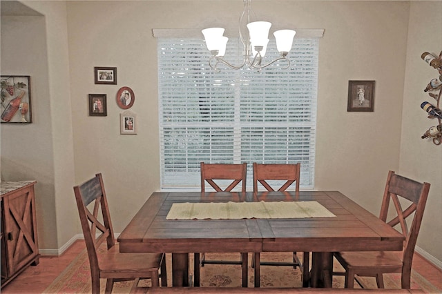 dining space with a notable chandelier and light wood-type flooring