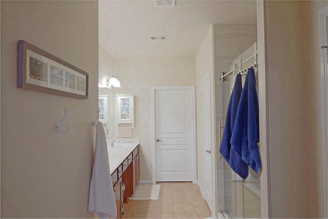 bathroom featuring vanity, tile patterned floors, and a shower with shower door