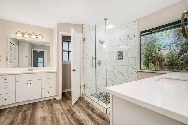 full bathroom featuring a stall shower, vanity, and wood finished floors