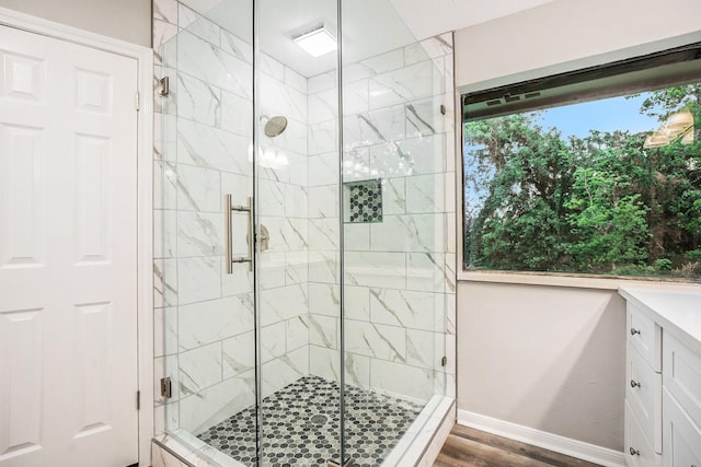 full bathroom with a stall shower, plenty of natural light, and wood finished floors