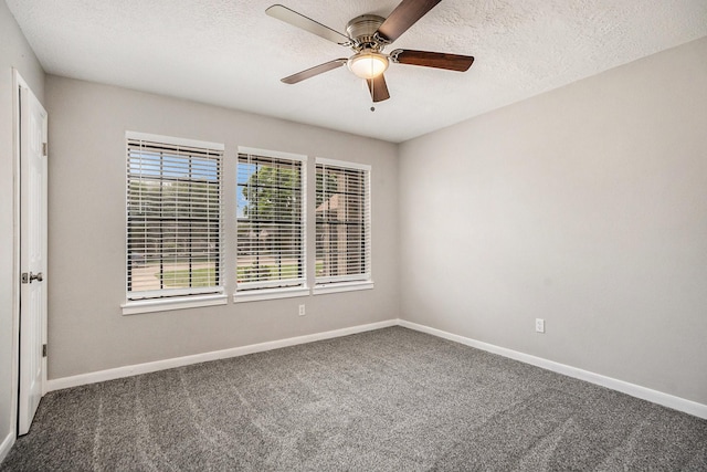 carpeted spare room with a textured ceiling, ceiling fan, and baseboards