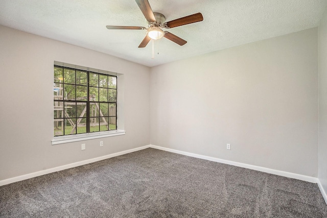 carpeted spare room featuring a textured ceiling, a ceiling fan, and baseboards