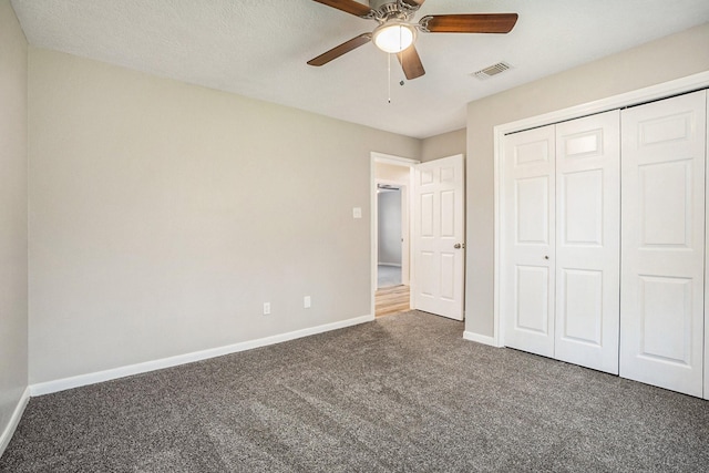 unfurnished bedroom with visible vents, baseboards, ceiling fan, carpet, and a closet