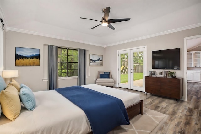 bedroom with a barn door, multiple windows, access to outside, and wood finished floors