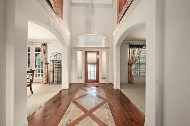 foyer with crown molding, french doors, and a high ceiling