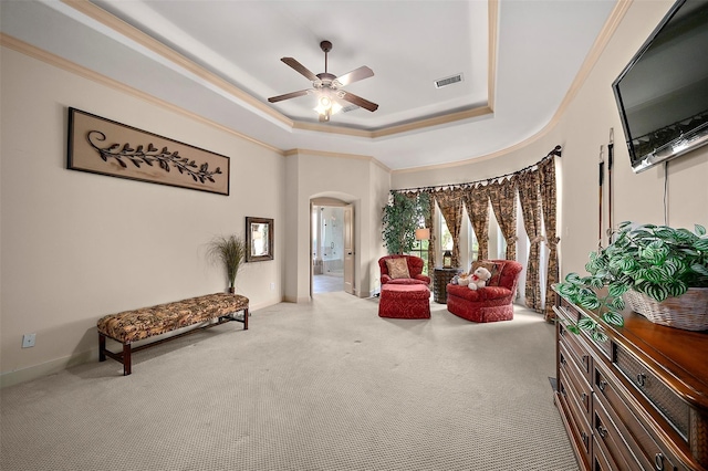 sitting room featuring a tray ceiling, ceiling fan, crown molding, and carpet