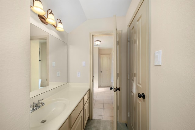 bathroom with tile patterned flooring, vanity, and lofted ceiling