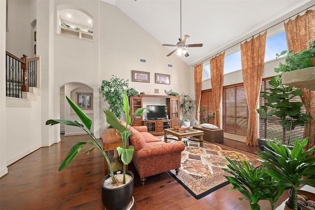 living room with ceiling fan, dark hardwood / wood-style flooring, and a high ceiling