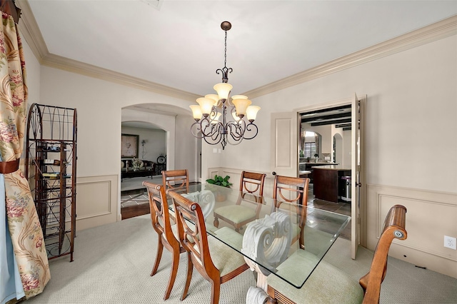 dining area with carpet flooring, a chandelier, and ornamental molding