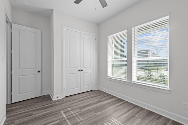 unfurnished bedroom featuring a closet, ceiling fan, and hardwood / wood-style flooring