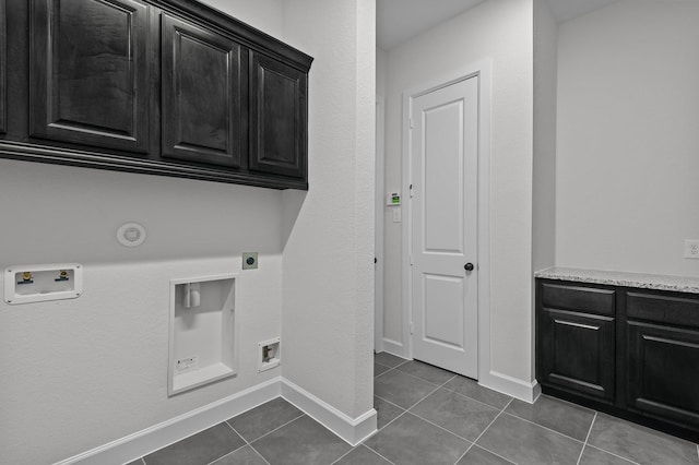 washroom featuring cabinets, hookup for a washing machine, hookup for an electric dryer, dark tile patterned flooring, and hookup for a gas dryer