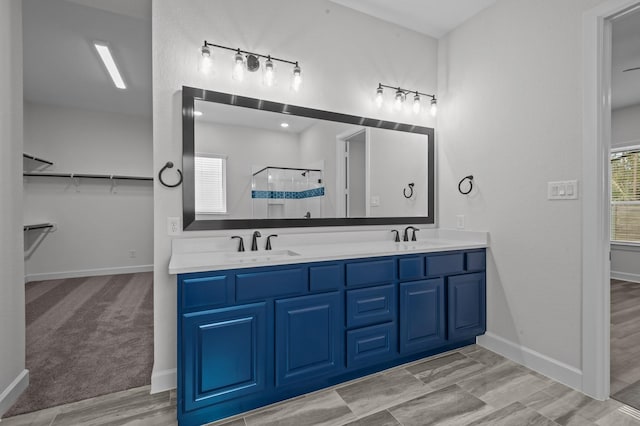 bathroom with a wealth of natural light, a shower with door, and vanity