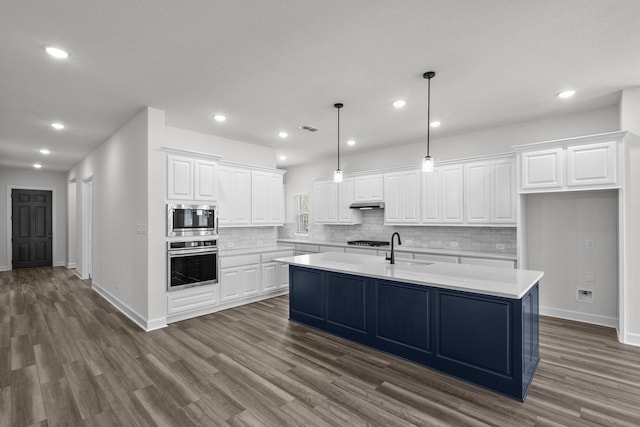 17007 Sweet Iris Ct, Conroe, TX 77302 - kitchen with stainless steel appliances, light countertops, dark wood-type flooring, and recessed lighting