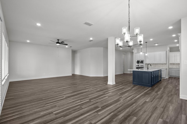 17007 Sweet Iris Ct, Conroe, TX 77302 - unfurnished living room featuring a sink, ceiling fan, recessed lighting, a chandelier, and dark wood-type flooring