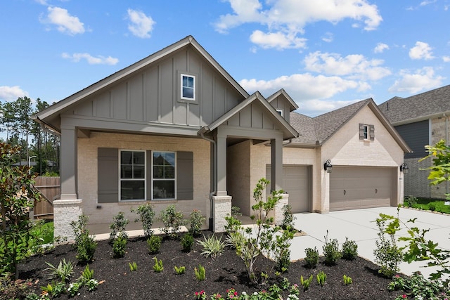 17007 Sweet Iris Ct, Conroe, TX 77302 - view of front of property with board and batten siding, an attached garage, concrete driveway, and brick siding