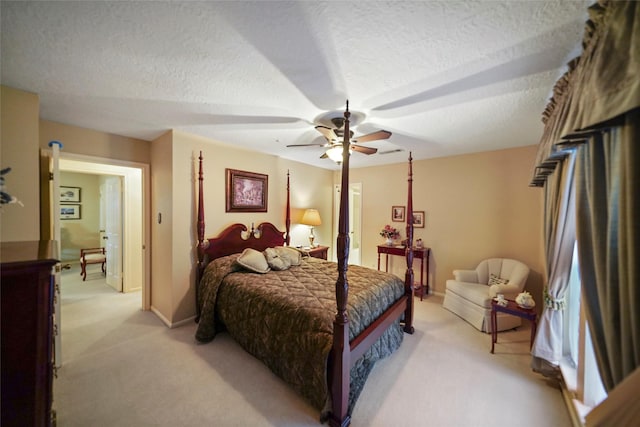 carpeted bedroom featuring ceiling fan and a textured ceiling