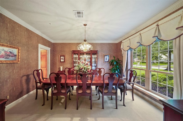 dining area with ornamental molding, a healthy amount of sunlight, carpet flooring, and a notable chandelier