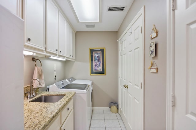 laundry room with cabinets, sink, light tile patterned floors, and washing machine and clothes dryer