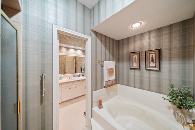 bathroom featuring a textured ceiling, vanity, and plus walk in shower