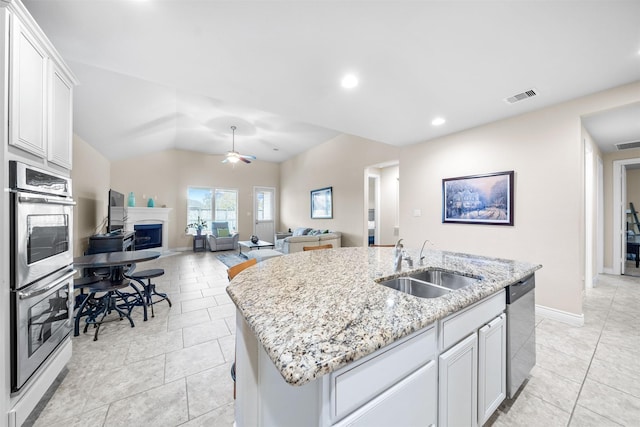 kitchen with white cabinetry, sink, ceiling fan, a center island with sink, and appliances with stainless steel finishes