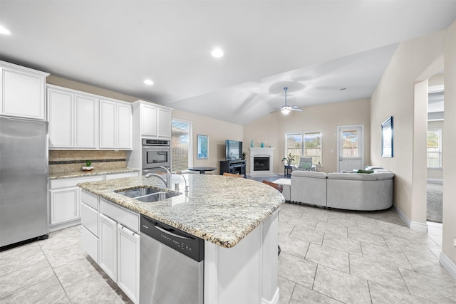 kitchen with sink, lofted ceiling, a kitchen island with sink, white cabinets, and appliances with stainless steel finishes