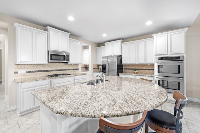 kitchen featuring sink, an island with sink, and stainless steel appliances