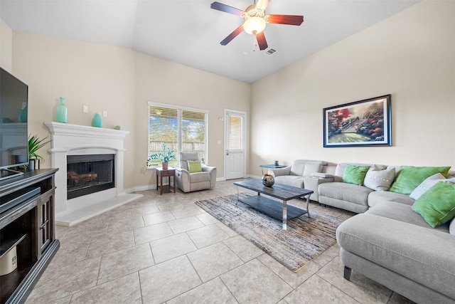 living room featuring ceiling fan, light tile patterned floors, and vaulted ceiling