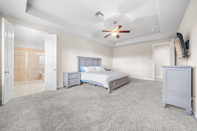 unfurnished bedroom with light carpet, a tray ceiling, and ceiling fan