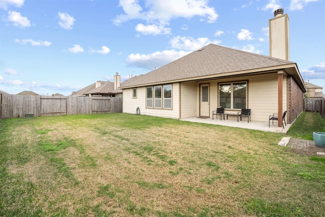 rear view of house featuring a yard and a patio