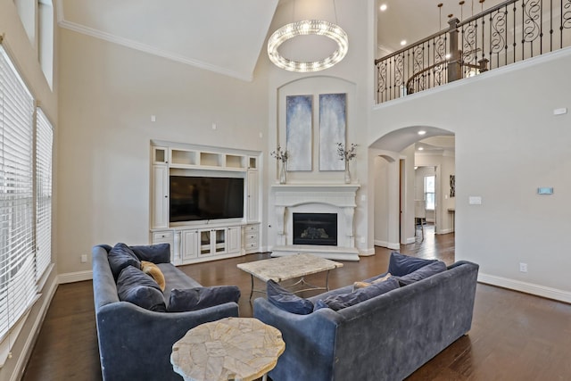 living room with a chandelier, crown molding, high vaulted ceiling, and dark wood-type flooring