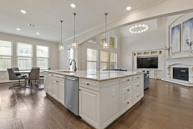 kitchen with dishwasher, a kitchen island with sink, white cabinets, sink, and decorative light fixtures