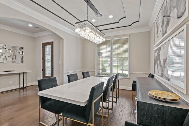 dining room with dark hardwood / wood-style flooring, an inviting chandelier, and crown molding