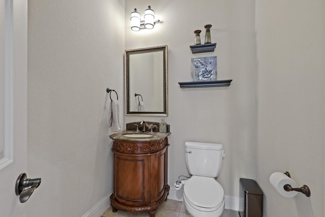 bathroom with toilet, vanity, and tile patterned floors