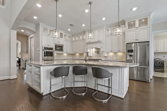 kitchen featuring a large island, hanging light fixtures, stainless steel appliances, and washer / clothes dryer