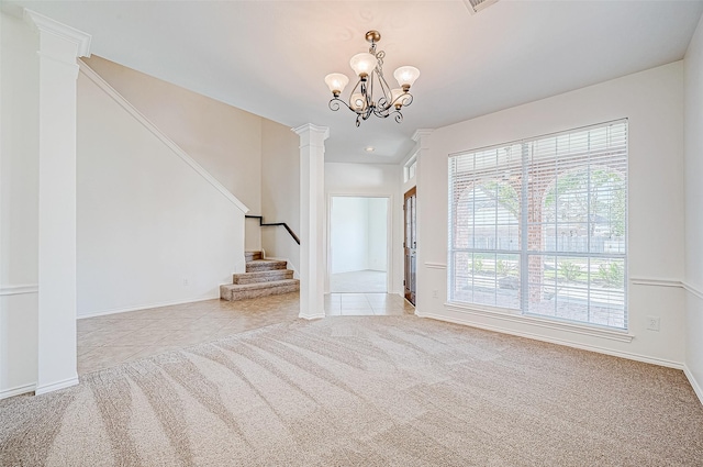 unfurnished living room with ornate columns, light carpet, a healthy amount of sunlight, and a notable chandelier