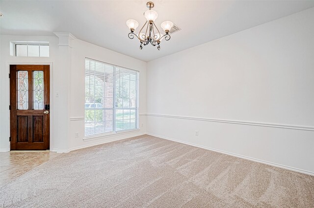 foyer with light carpet and an inviting chandelier