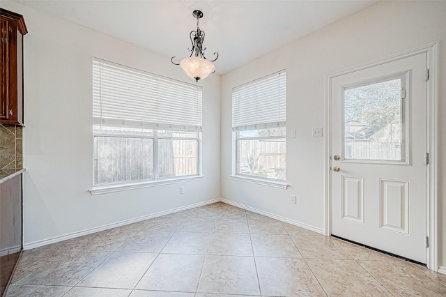 unfurnished dining area with light tile patterned floors and a chandelier