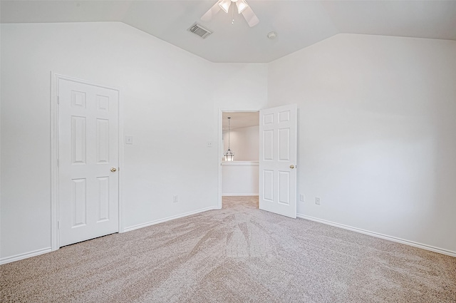 unfurnished bedroom with visible vents, baseboards, carpet, and vaulted ceiling